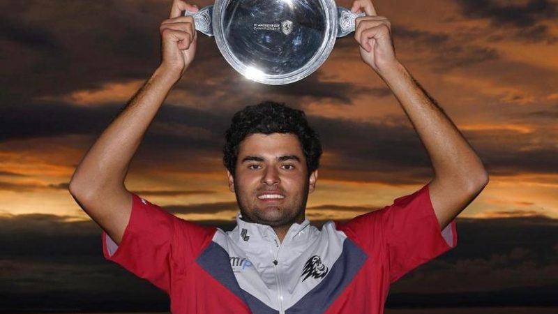 golfer holds trophy aloft