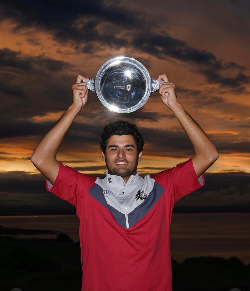 golfer holds trophy aloft